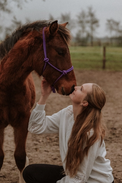 Paardencoach geeft paard een warme knuffel, straalt zorgzaamheid en liefde uit