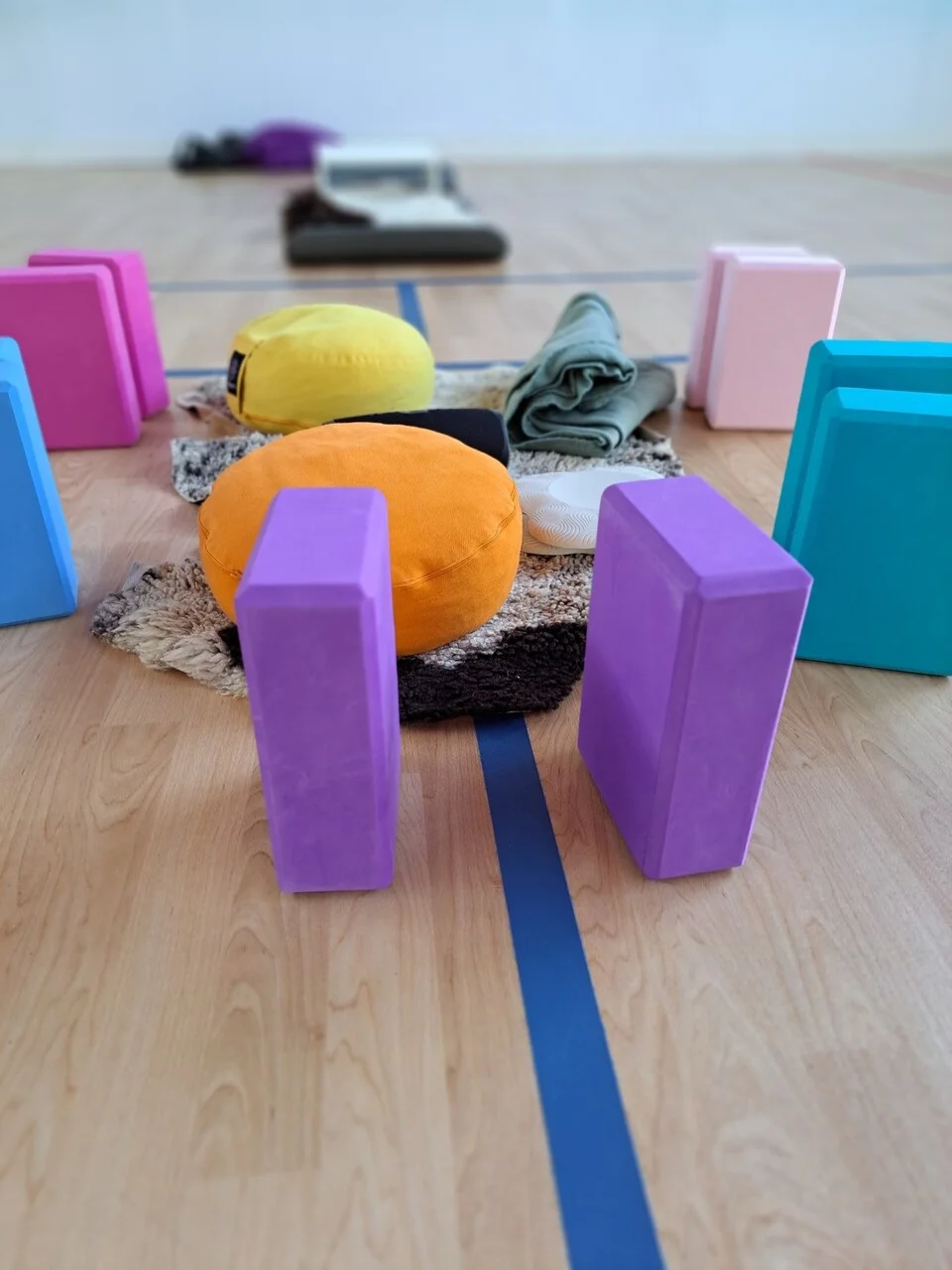 Rustige yogales in lesruimte met yogamat, kussens en kaarsen voor mindfulness en ontspanning